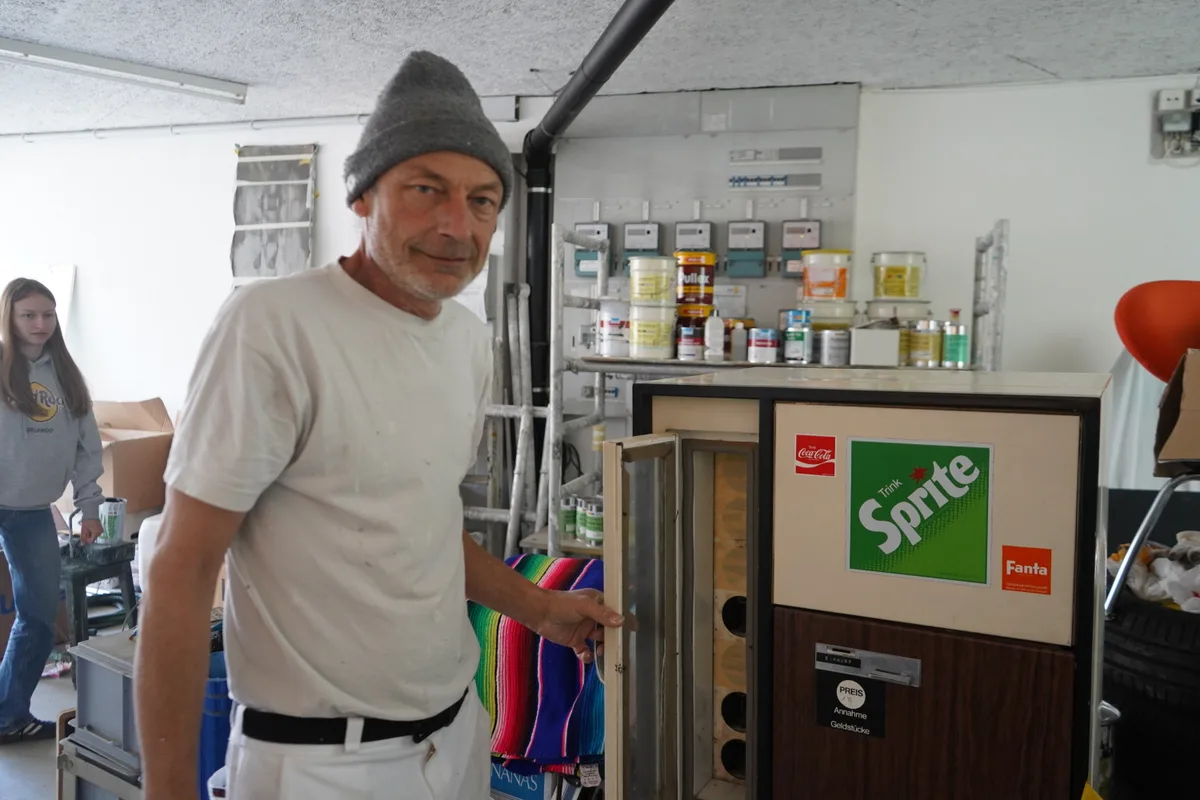 Man sieht Daniel Jaussi und seine Coca-Cola Sammlung.